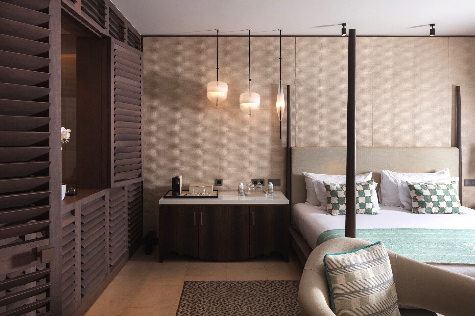 Una habitación de hotel moderna con una cama, una mesita de noche y una silla.