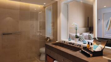 A modern bathroom with a glass-enclosed shower, a large mirror, and a vanity with a sink and multiple toiletries.