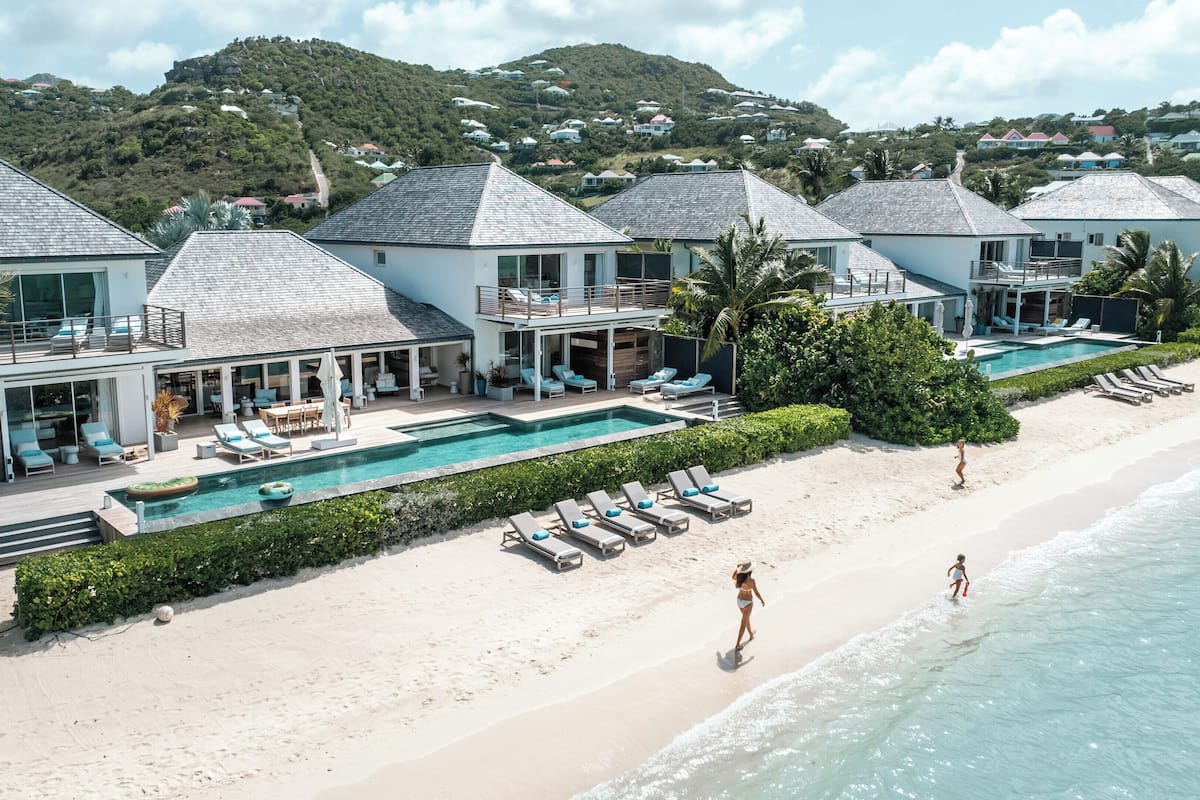 A beachfront resort with multiple villas, a swimming pool, and a beach.