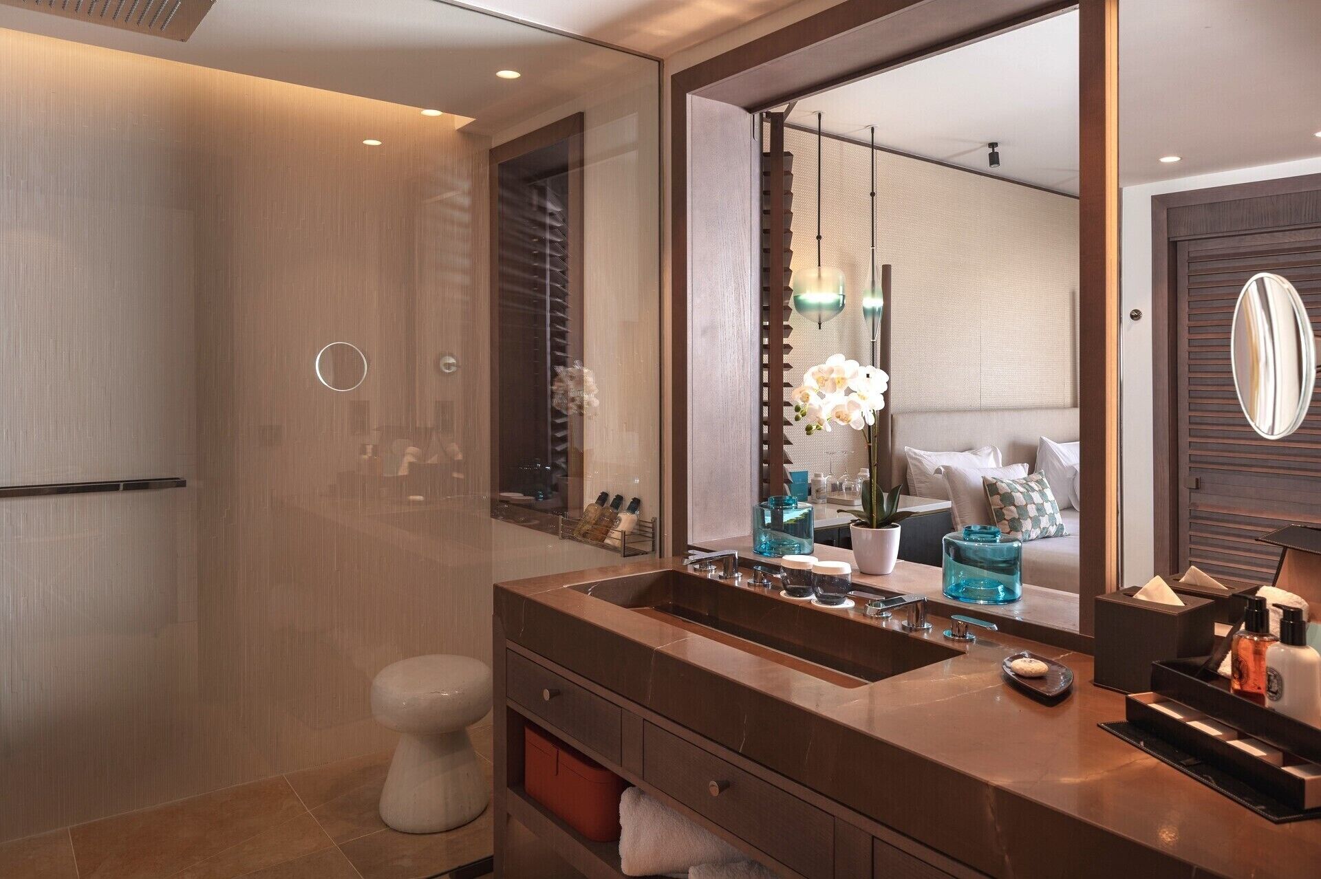 A modern bathroom with a large mirror, a double sink vanity, and a walk-in shower.