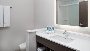 A modern bathroom with a white sink, a large mirror, and a towel rack. - Holiday Inn Express & Suites Kingdom City by IHG (Kingdom City)