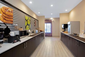 A modern kitchen with a long counter, microwave, and coffee machine. - La Quinta Inn & Suites by Wyndham West Monroe (West Monroe)