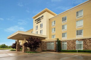 Un hotel de diseño moderno, con un cartel llamativo de 'TOINEPLACE SUITES MARIEOTTE'. Tiene un acceso cubierto y un área de estacionamiento.
