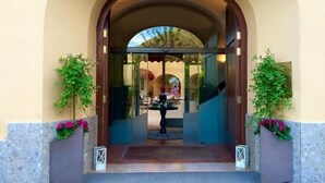An entrance with an arched doorway, a small fountain, and potted plants on either side. - San Leucio Resort (Caserta)