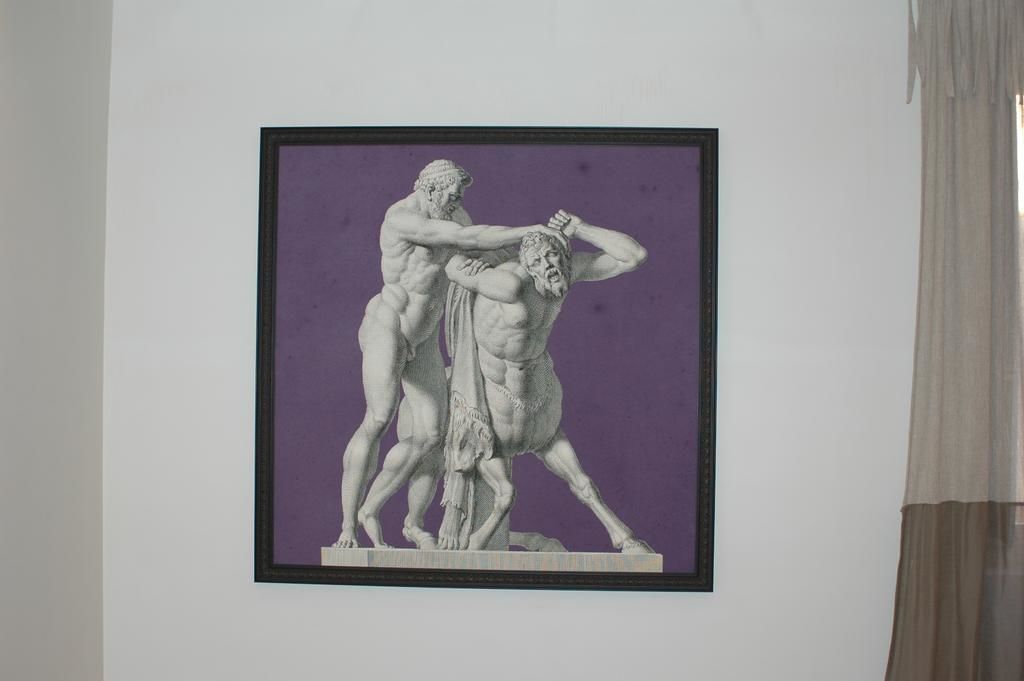 Eine gerahmte Skulptur von zwei Figuren an einer Wand.
