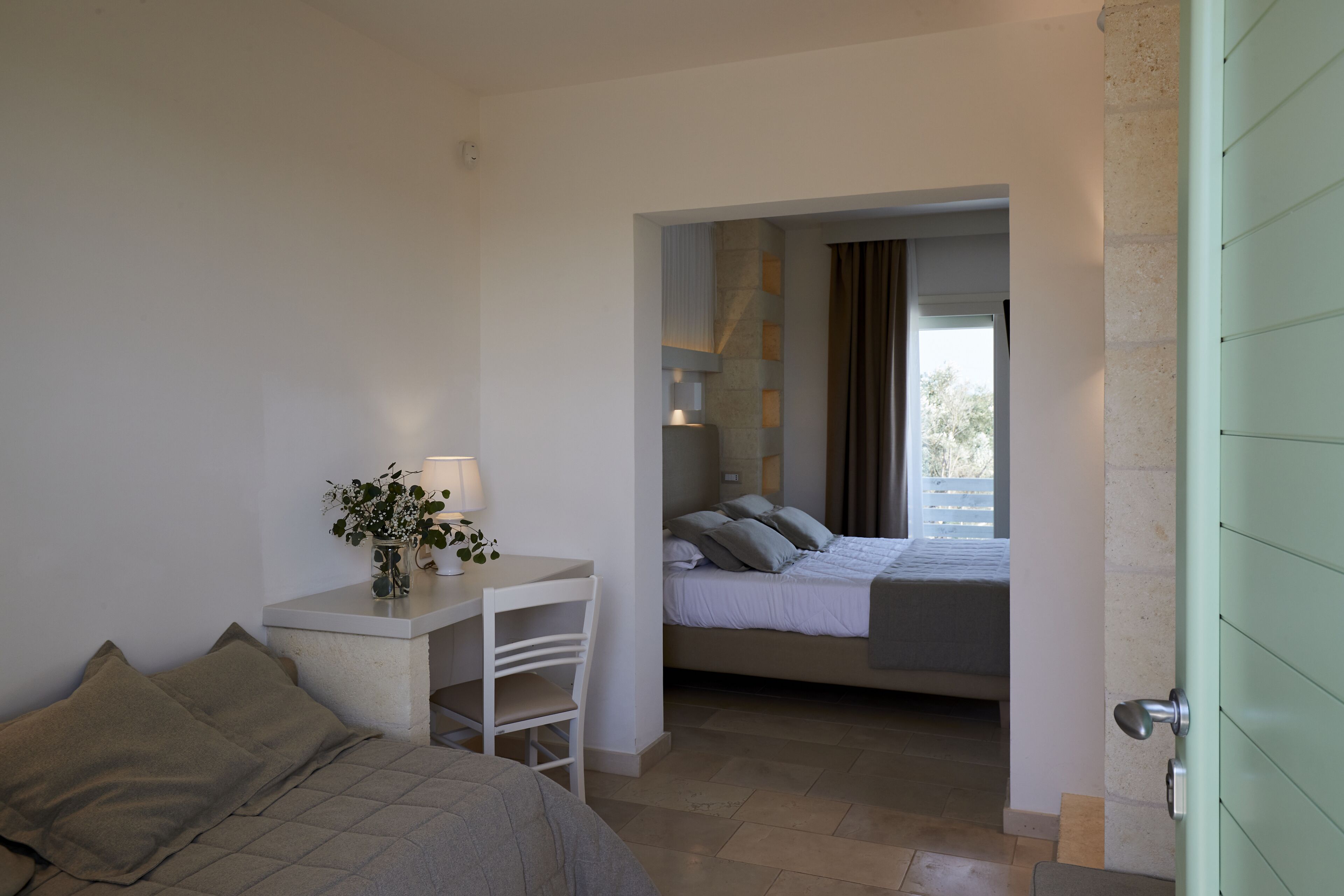 Une chambre à coucher avec un lit, un bureau avec une lampe et une chaise.