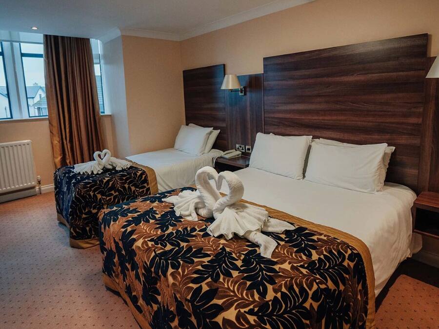 Een hotelkamer met twee bedden, uitzicht naar buiten en een stoel.