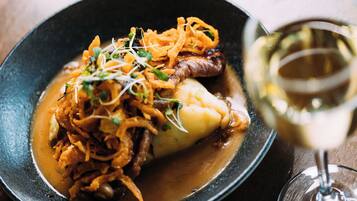 A plate of food with a glass of white wine.