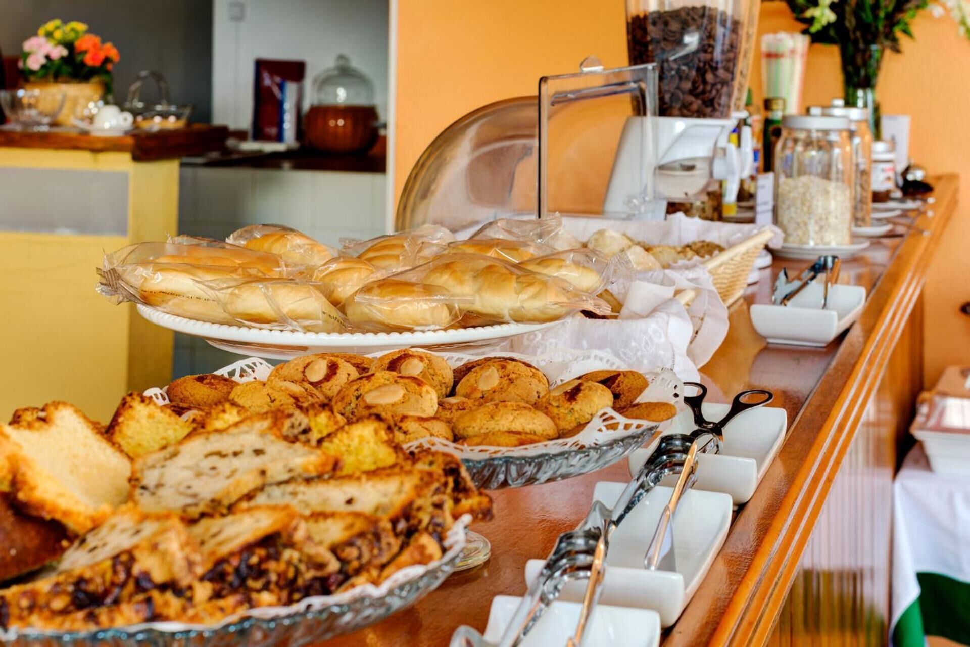 A buffet with various baked goods including pastries and bread.