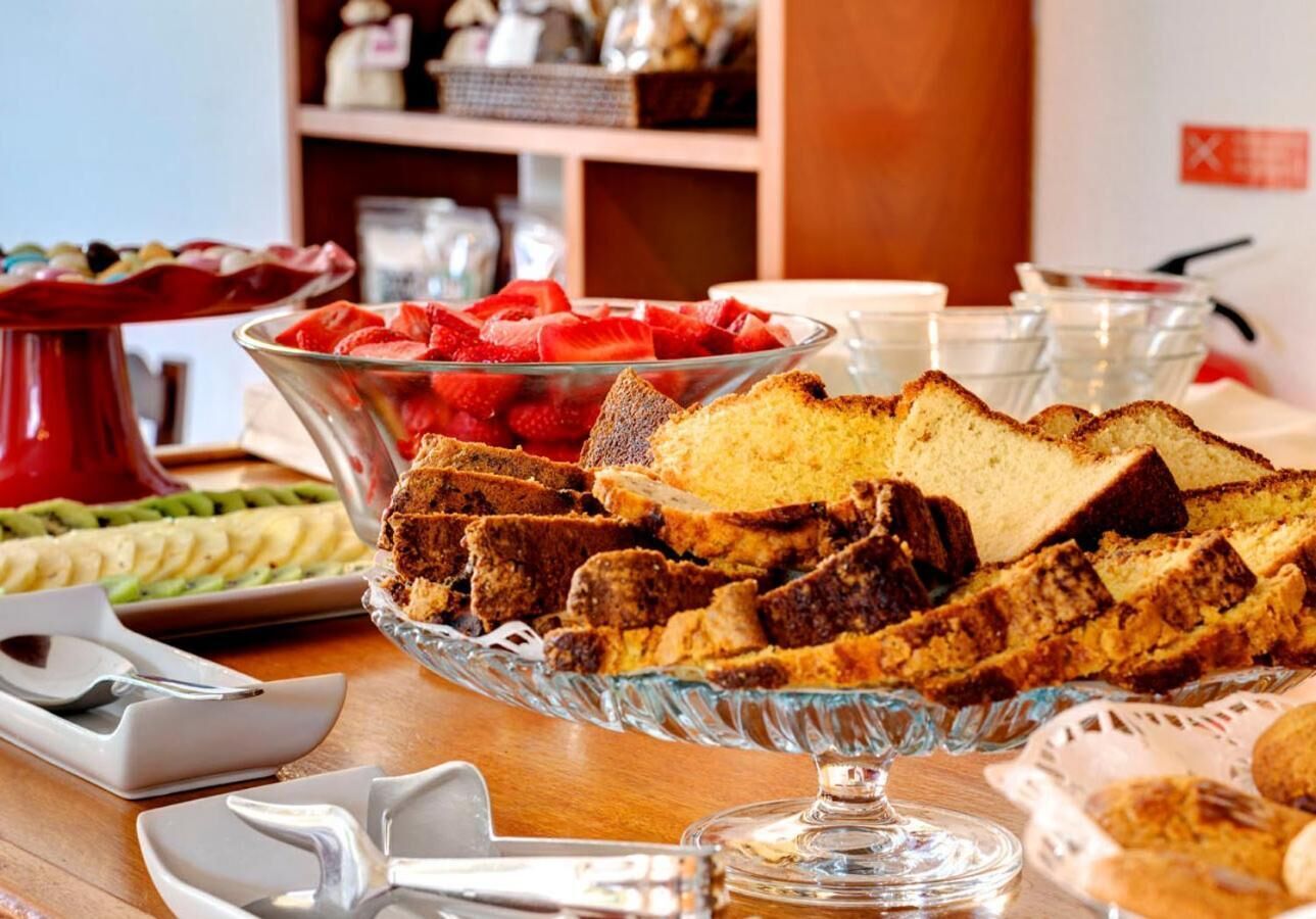 Une table de buffet proposant divers aliments, notamment des tranches de pain, des fraises et d’autres fruits.