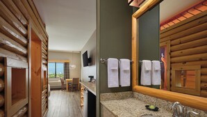 A wooden interior with a kitchen area, a dining table, and a large mirror. - Great Wolf Lodge Anaheim, CA (Garden Grove)