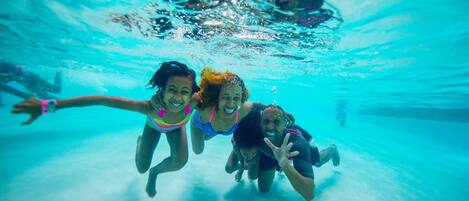 An underwater view of a swimming pool with clear water.