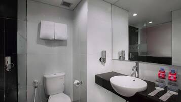 A modern bathroom with a white toilet, a sink, and a mirror.