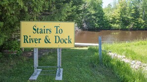 Señal que indica escaleras hacia un río y un muelle.
