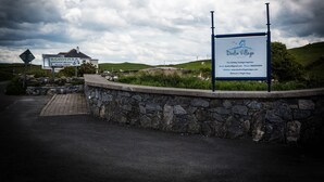 A sign for 'Doolin Village' with contact information and a website. - Doolin Village Lodges (Doolin)