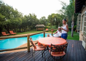 Una piscina al aire libre, sillones reclinables de piscina