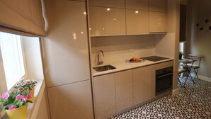 Una cocina compacta con dos fregaderos, horno integrado y ventana con vistas.