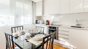 Une cuisine moderne avec des armoires blanches, un four à micro-ondes et un évier.