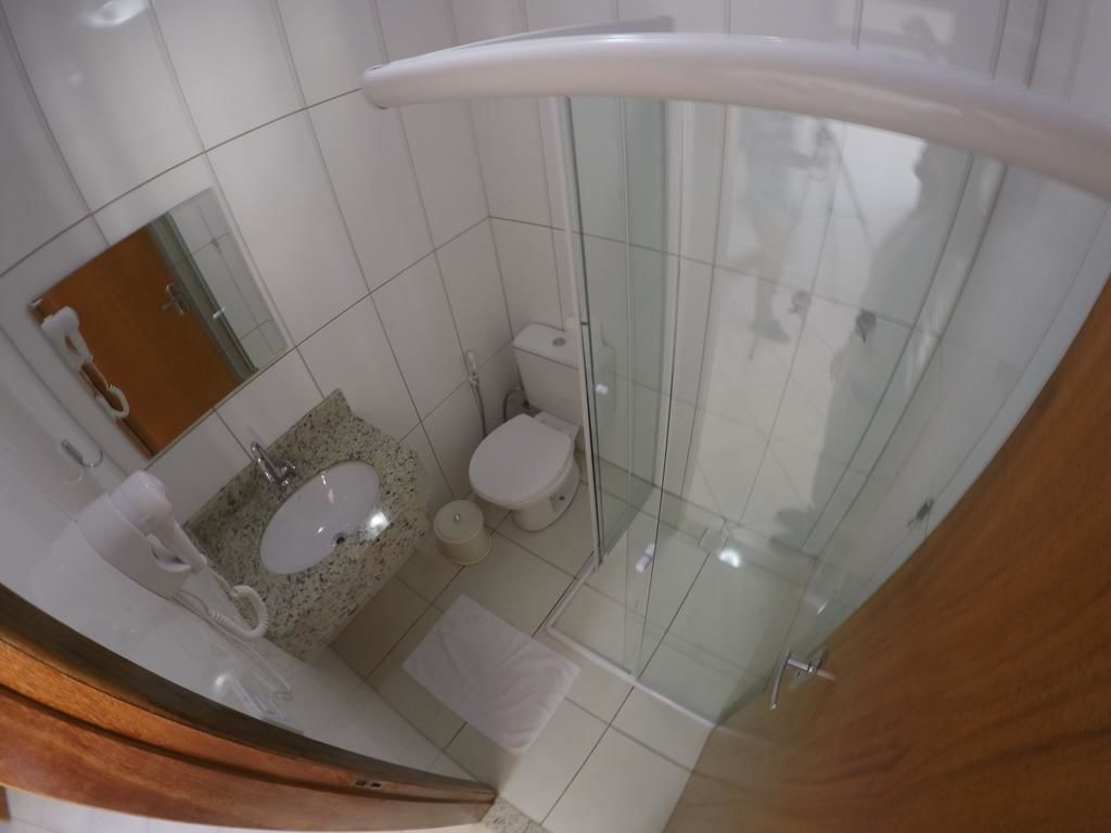 Un baño con cabina de ducha de vidrio, un lavabo e inodoro.