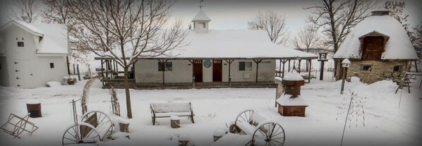 A snow-covered building with a traditional design, including a thatched roof and a bell tower. - Cupola Inn Bed & Breakfast (Nora Springs)