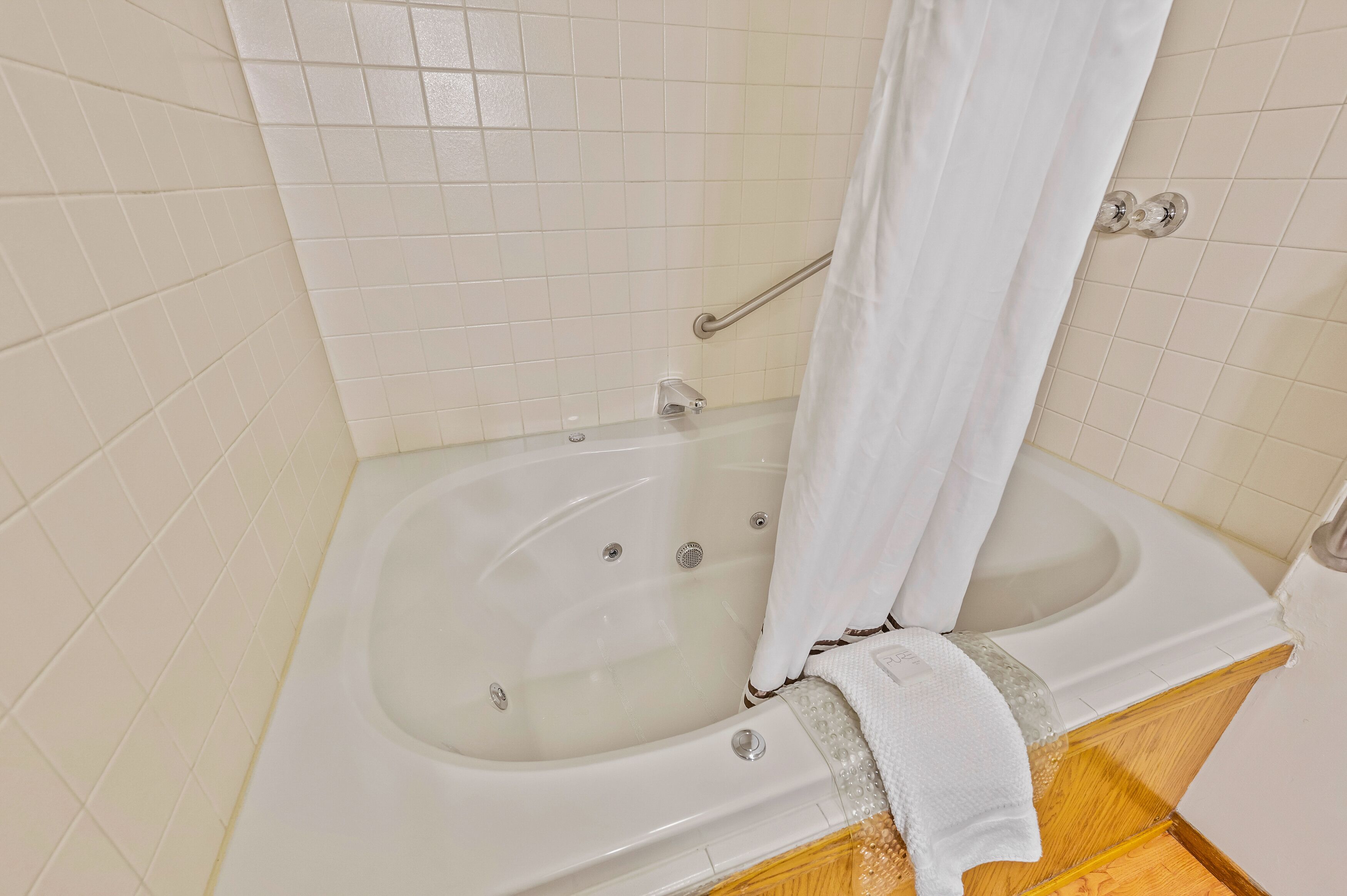A bathroom with a bathtub, a toilet, and a shower curtain.