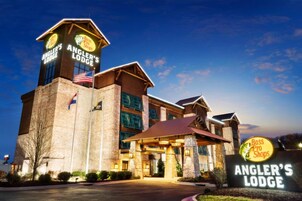 A hotel with a prominent tower and a sign for 'Angler's Lodge' and 'Bass Pro Shops'.