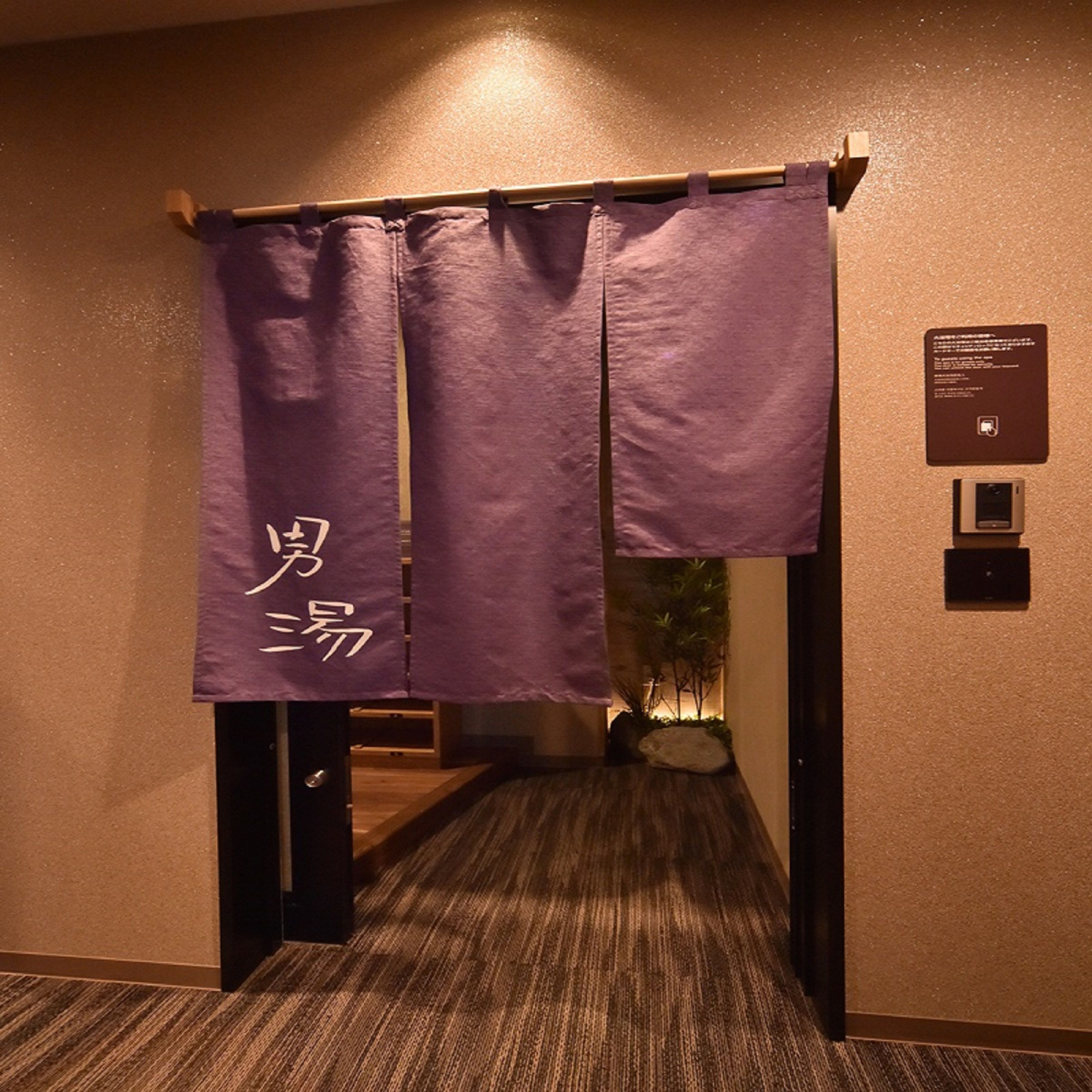 A hallway with a purple curtain and a sign on the wall.