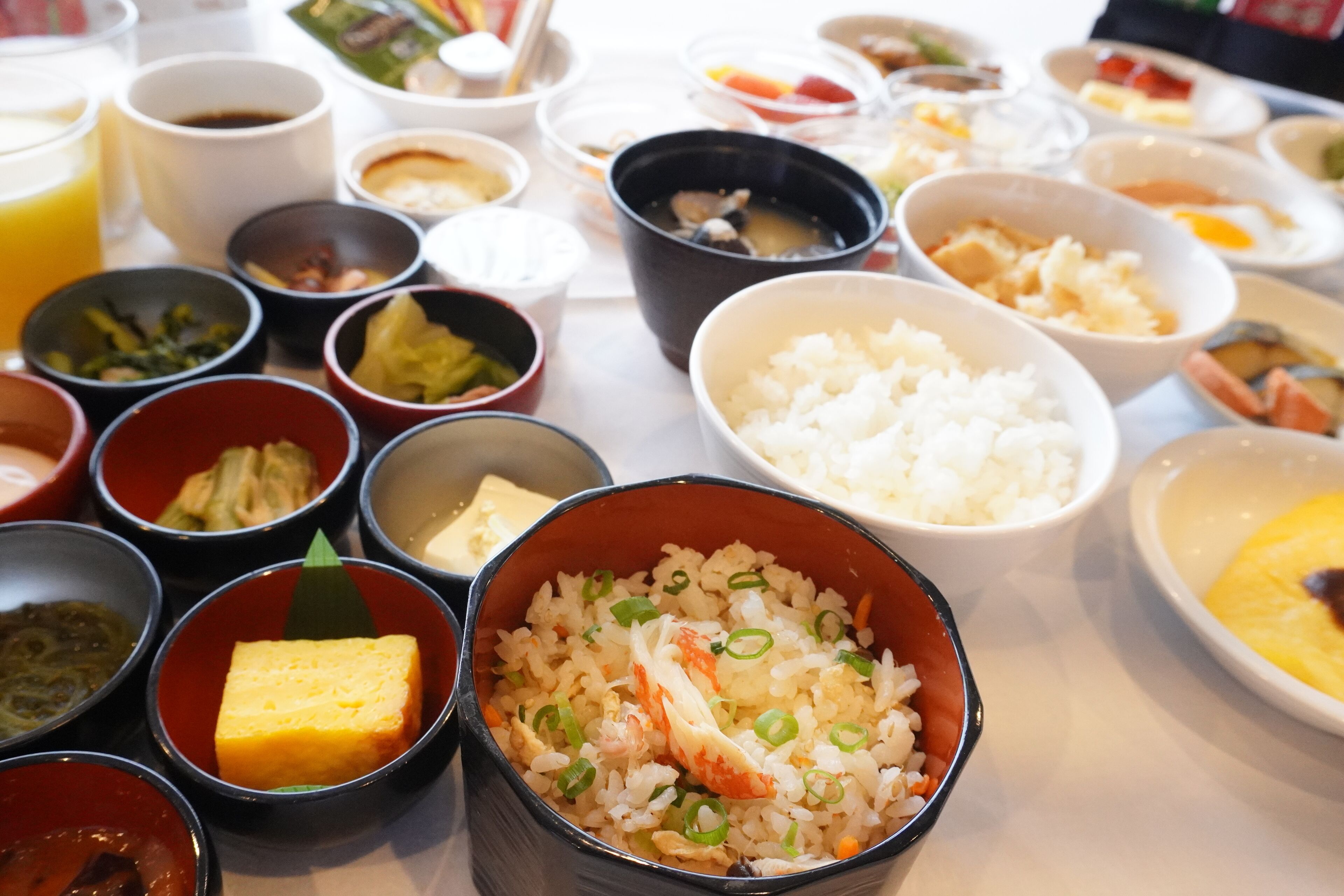 A table with various dishes including rice, soup, and other small bowls of food.