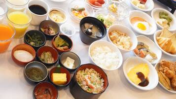A table with various dishes and condiments, including rice, eggs, and vegetables.