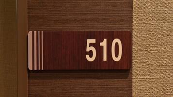 A wooden room number plaque with the number 510 on a textured wall.