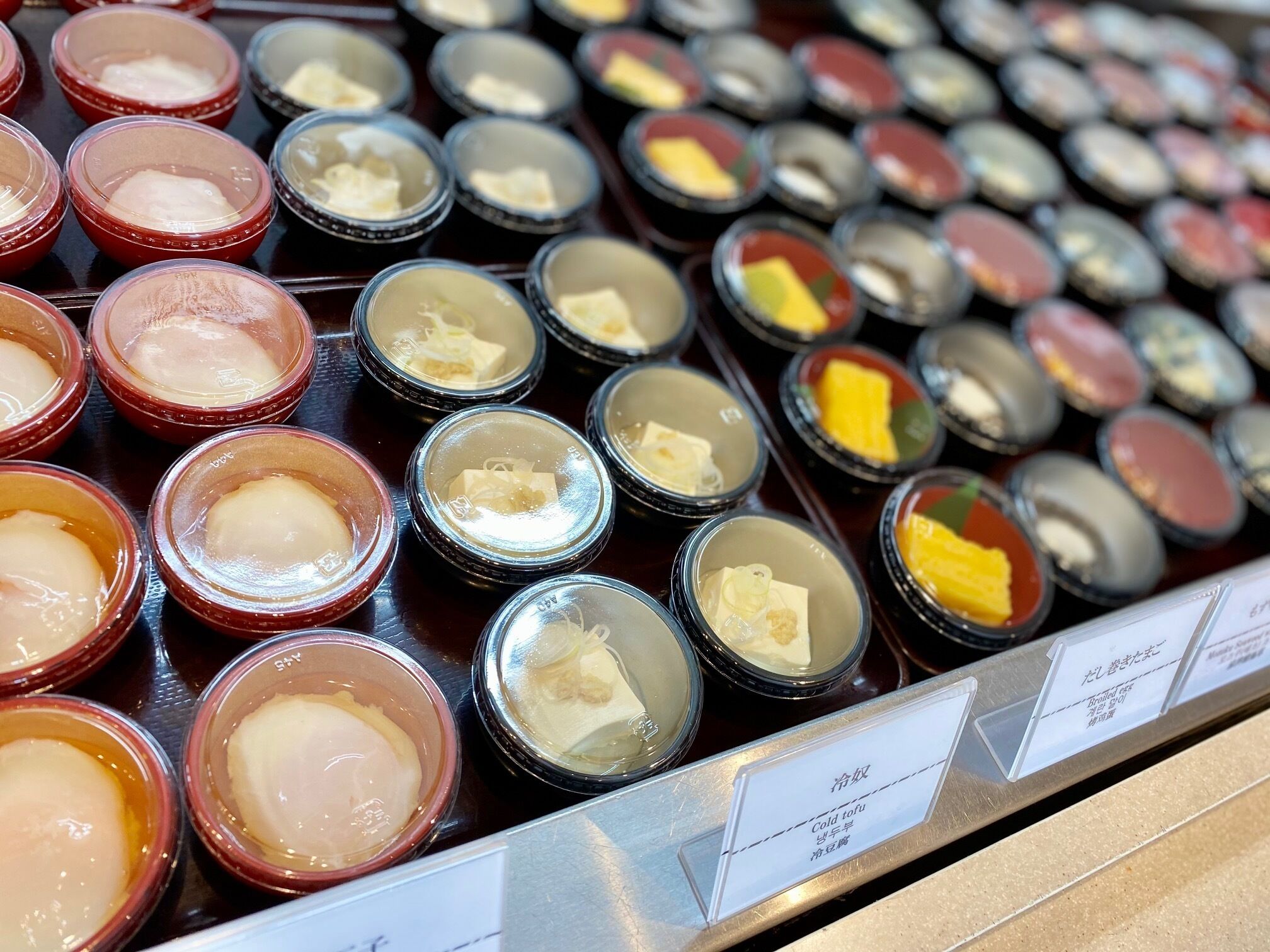 A display of various condiments in small containers, each labeled with its name.