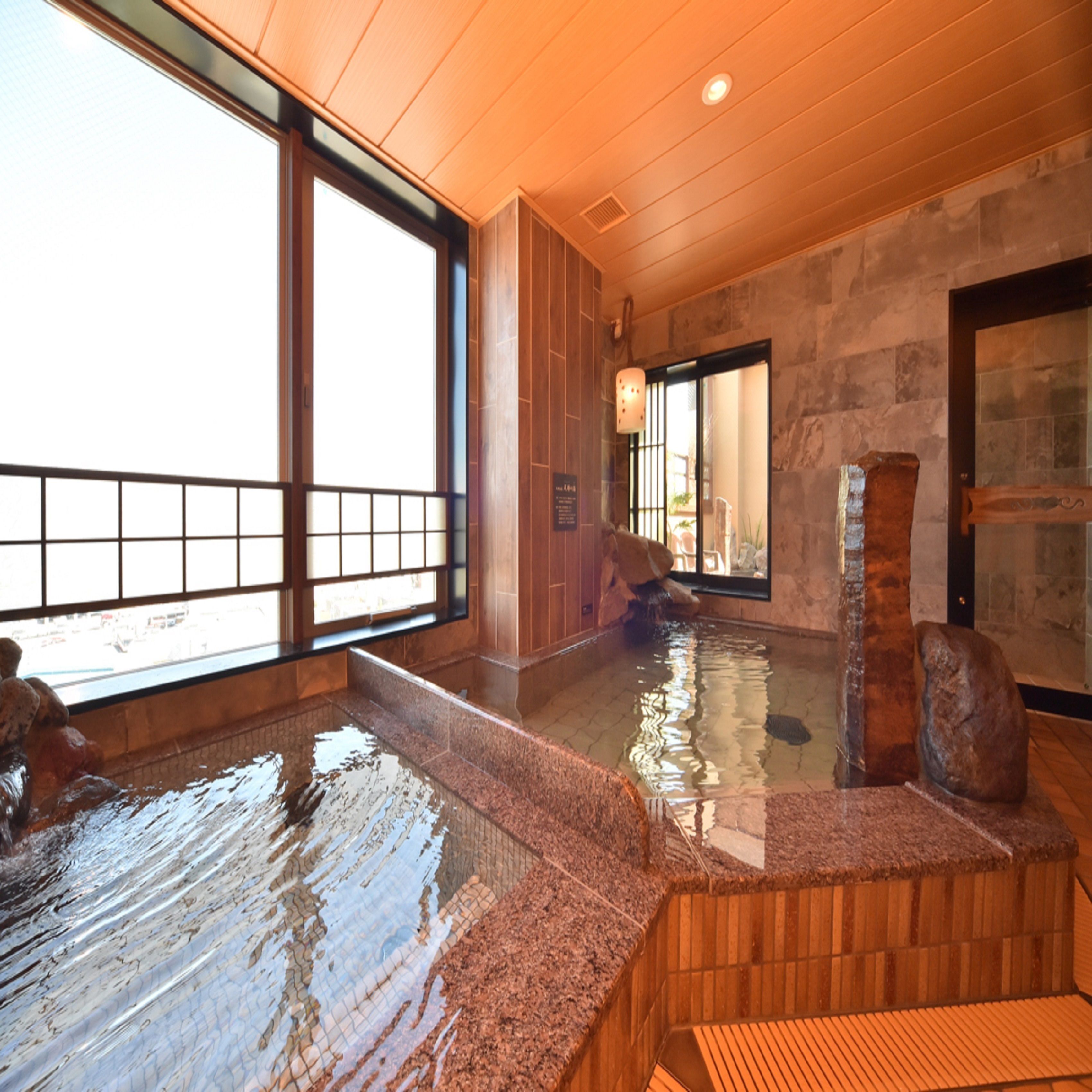 A hot spring area with wooden benches and a stone wall.