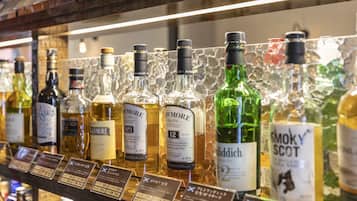 A selection of whisky bottles on a shelf with price tags.