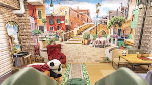 A cozy room with a panda plush toy, a red armchair, and a small table with a book. - OMOTENASHI Hostel Miyajima (Hatsukaichi)