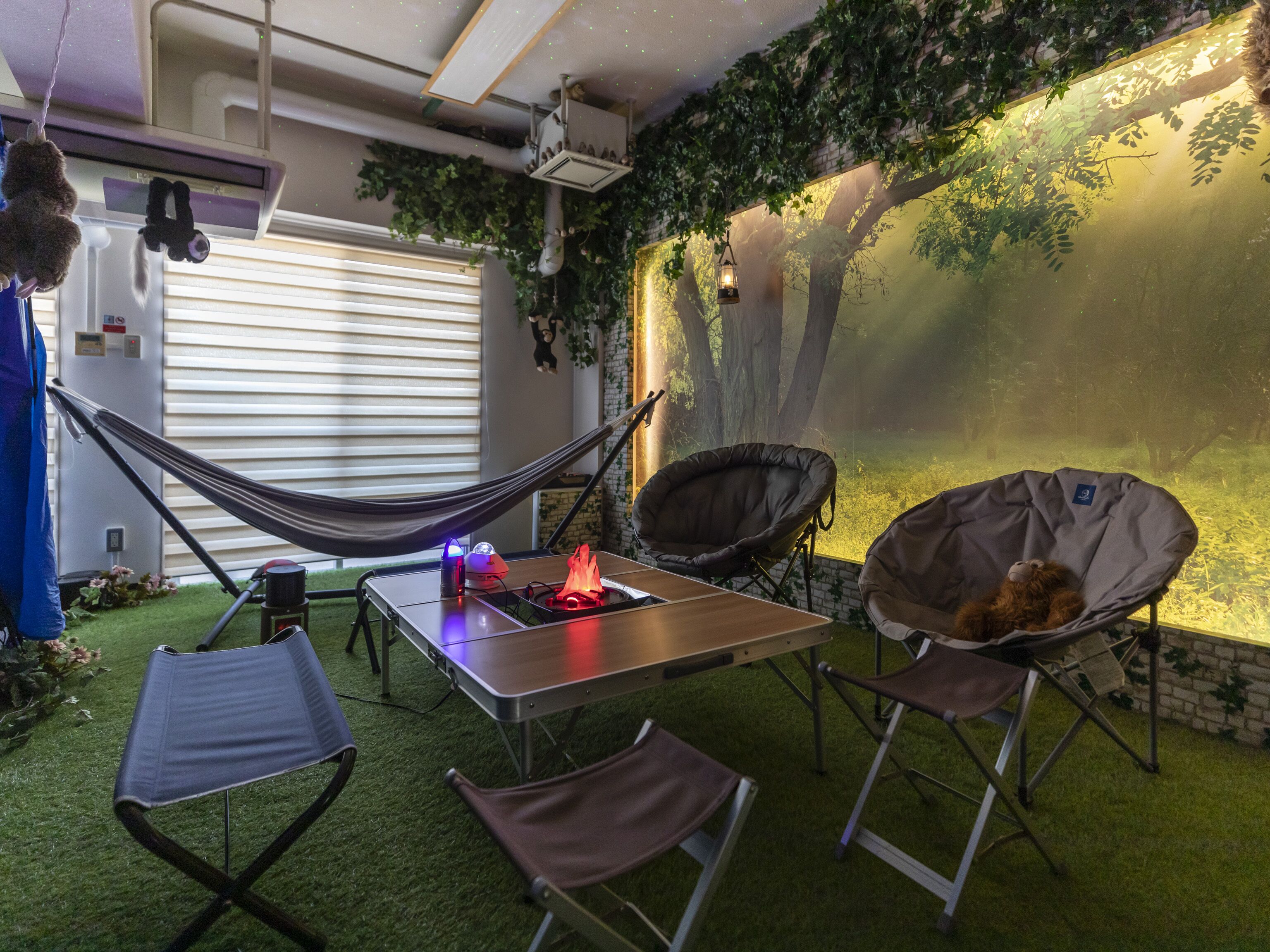 Un espacio al aire libre acogedor con una mesa, sillas y una hamaca.