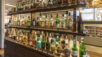 A bar with multiple shelves stocked with various liquor bottles.