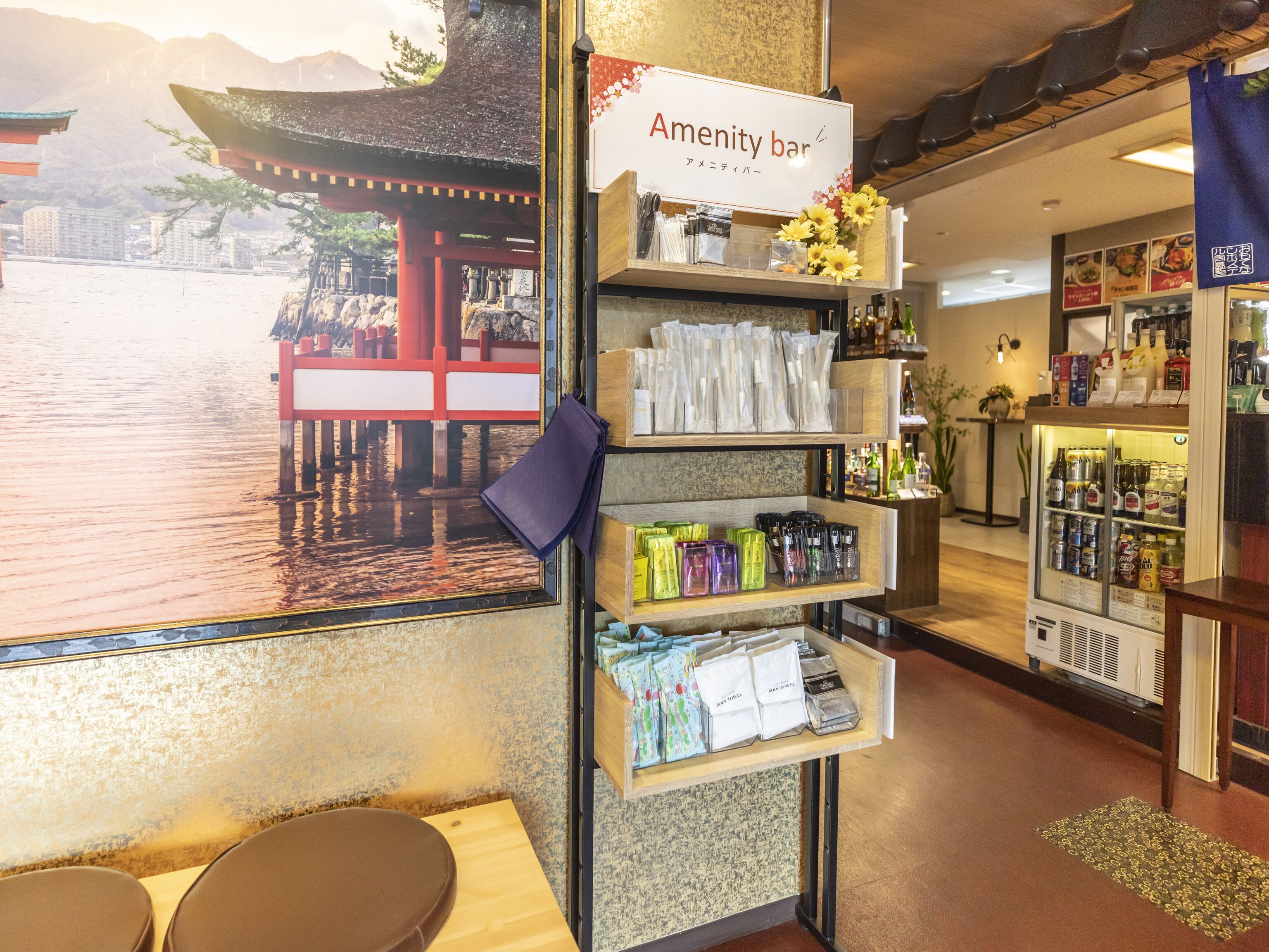 A bar area with a sign reading "Amenity bar," shelves with various items, and a view of a traditional Japanese structure outside.