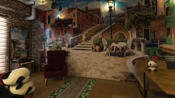 A cozy indoor setting with a brick wall, a red armchair, a sofa, and a table with a panda plush toy.