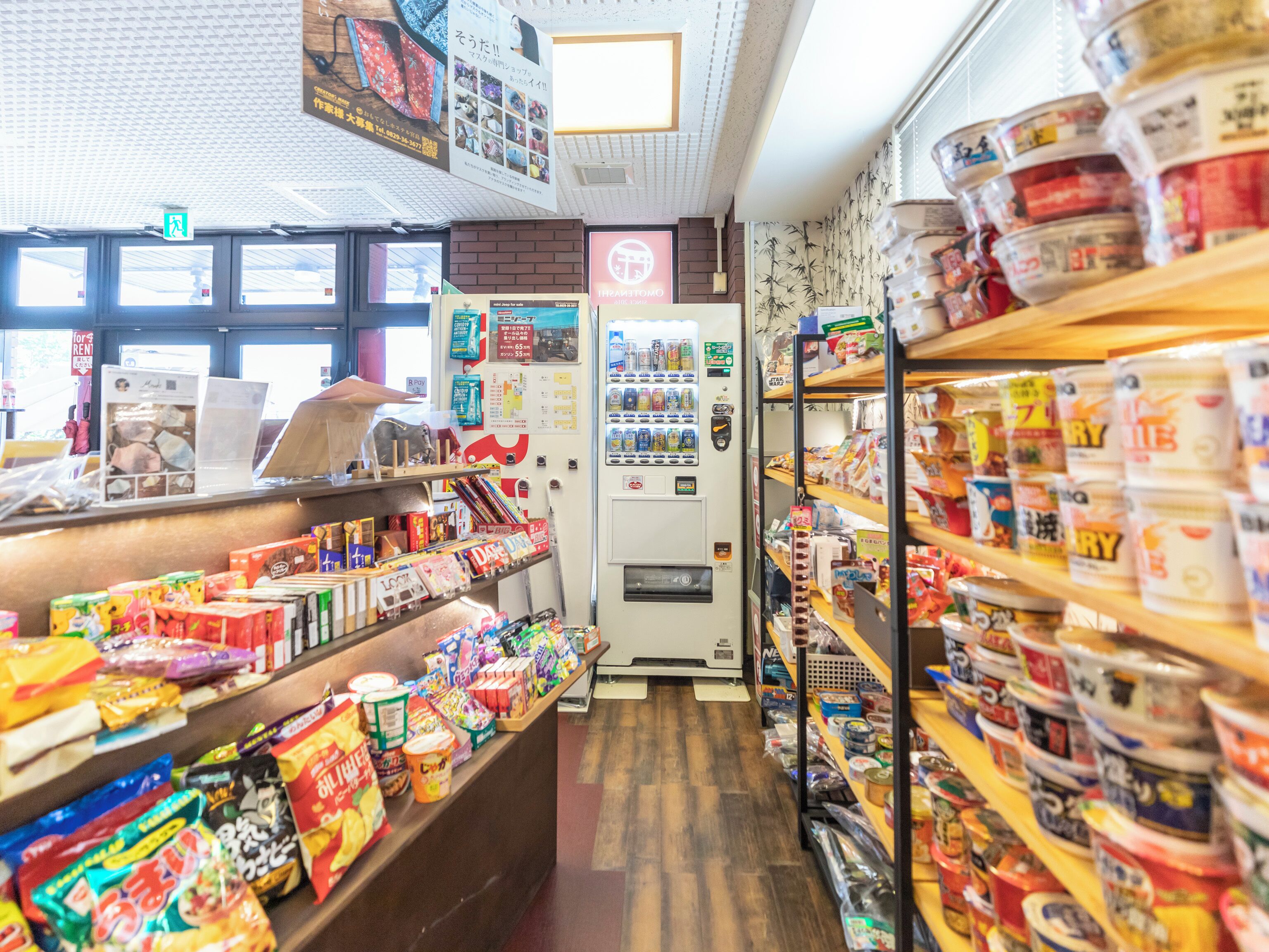 A store interior with shelves stocked with snacks and a vending machine.