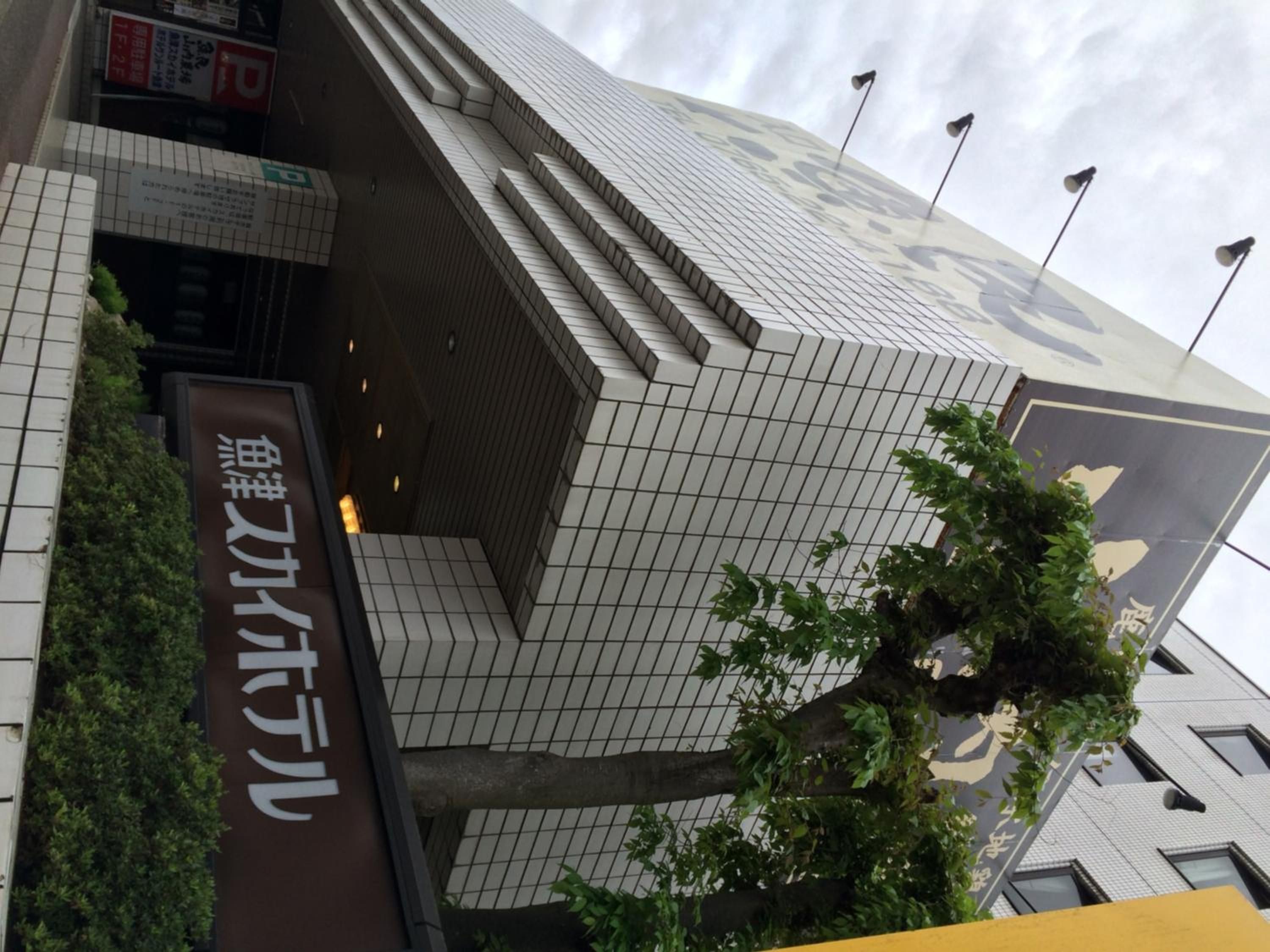 A modern building with a tiled facade and a sign with Japanese characters.
