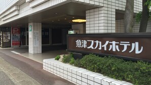 A building with a sign reading "Piscina Skai Hotel" and a parking sign indicating a parking area. - Sky Hotel Uozu Annex (Uozu)