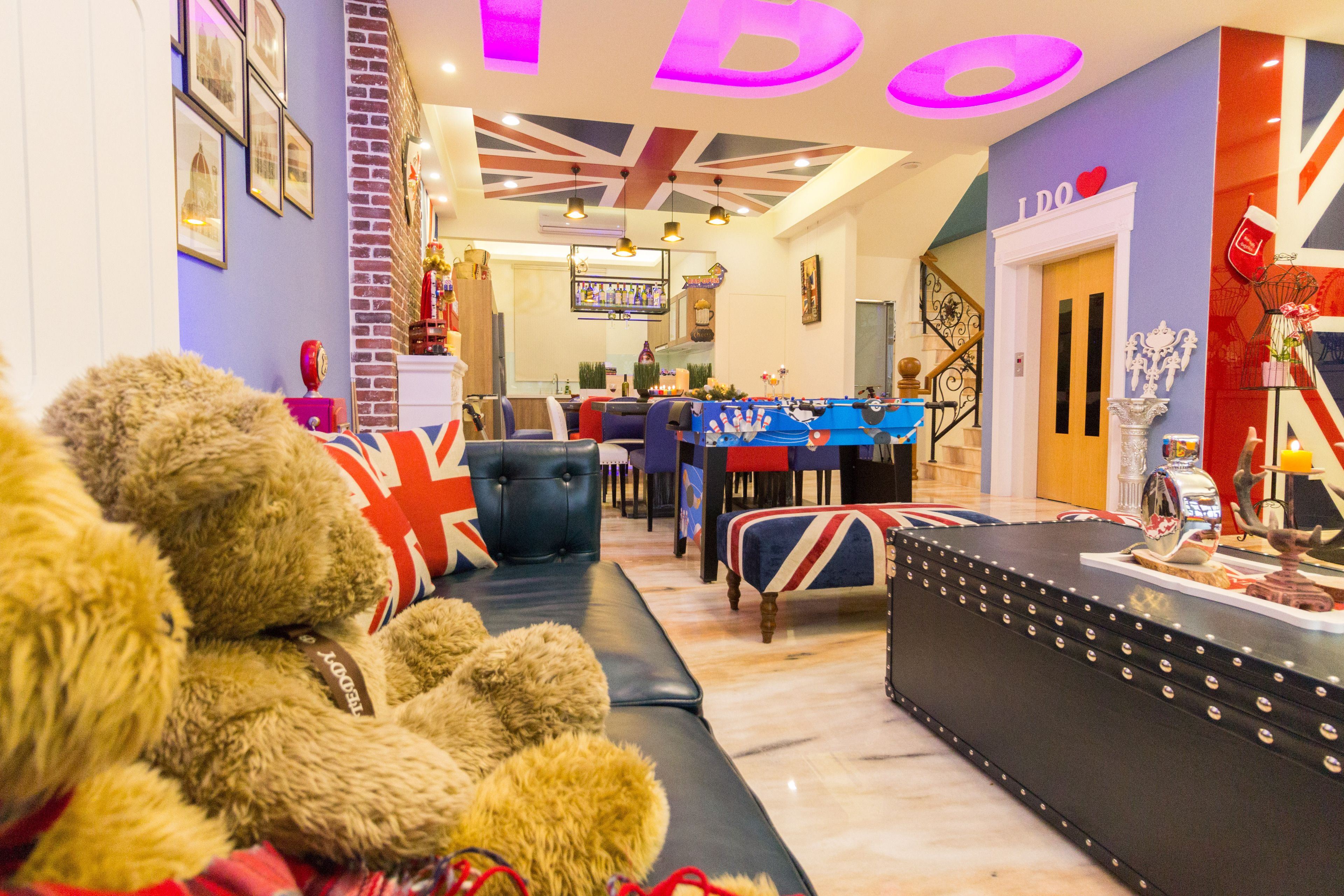 A cozy living room with a sofa, a table with a Union Jack tablecloth, and a Union Jack-themed wall.