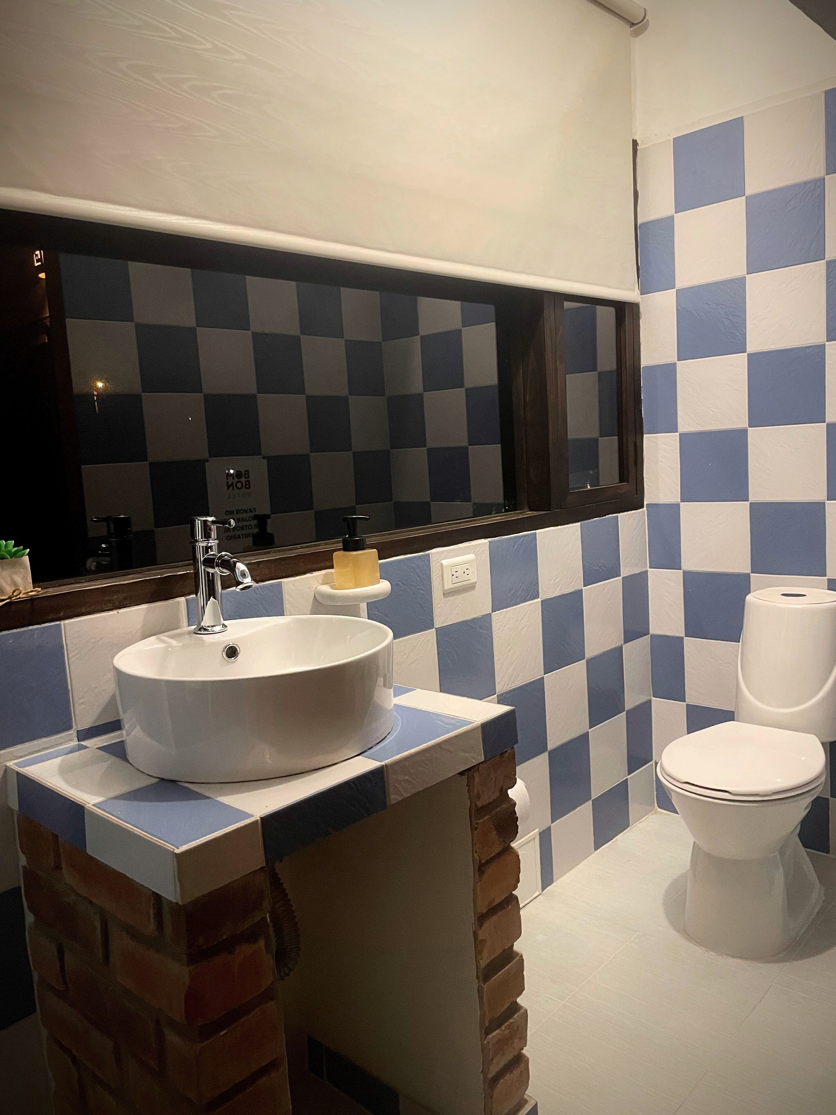A bathroom with a white sink, a mirror, and a toilet.