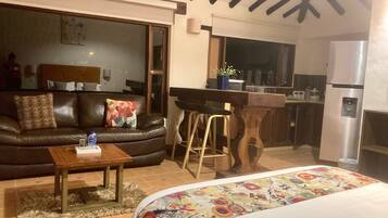 Un espacio de sala acogedor con un sofá, una mesa de centro y una colcha colorida.