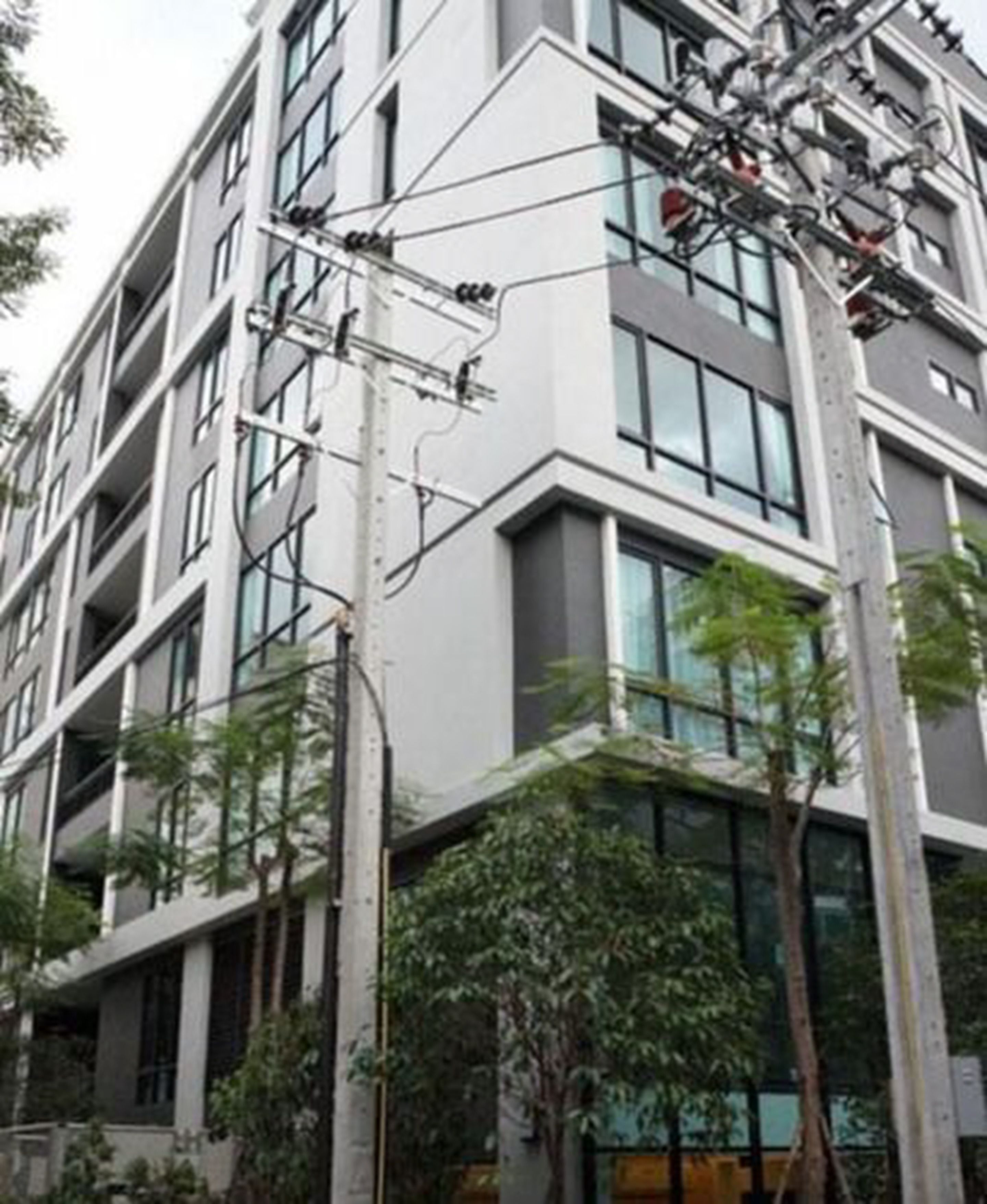 A multi-story building with a modern architectural design, featuring balconies and large windows.
