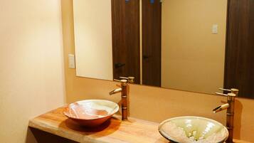 A bathroom with two sinks, a mirror, and a light fixture above the mirror.