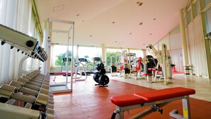 Une salle de sport équipée de divers appareils d’exercice, notamment des tapis de course et des appareils de musculation.