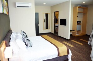 Ein Hotelzimmer mit einem Bett, einem Kleiderschrank, einem Fernseher und einer Klimaanlage.