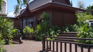 A traditional wooden building with a sloped roof and a wooden staircase leading to the entrance. - Kaya Mani Thai Villa Resort Samui (Koh Samui)