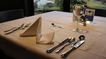 A table set for dining with cutlery, a glass, and a menu.